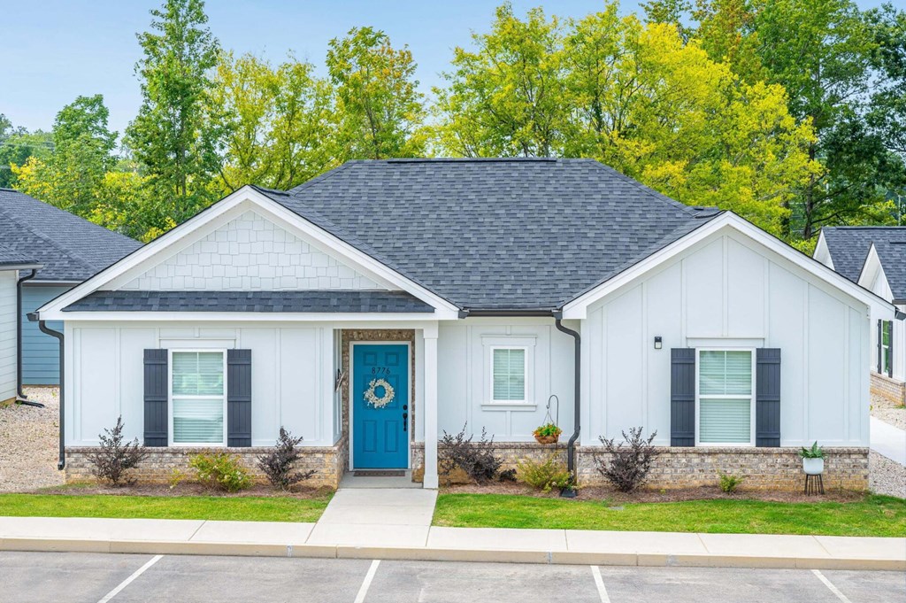 the front of a white house with a blue door