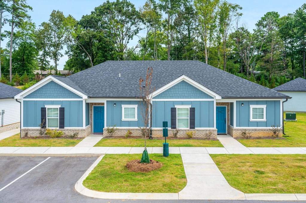 a blue house with blue doors and a sidewalk in front