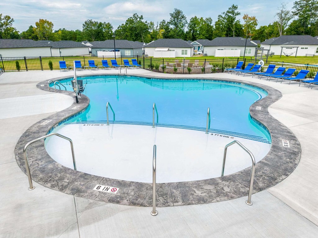 a swimming pool with blue chairs around it