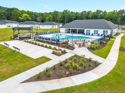 an aerial view of a swimming pool with a house in the background