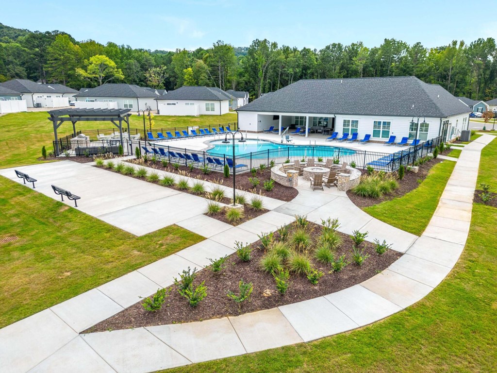an aerial view of a swimming pool with a house in the background