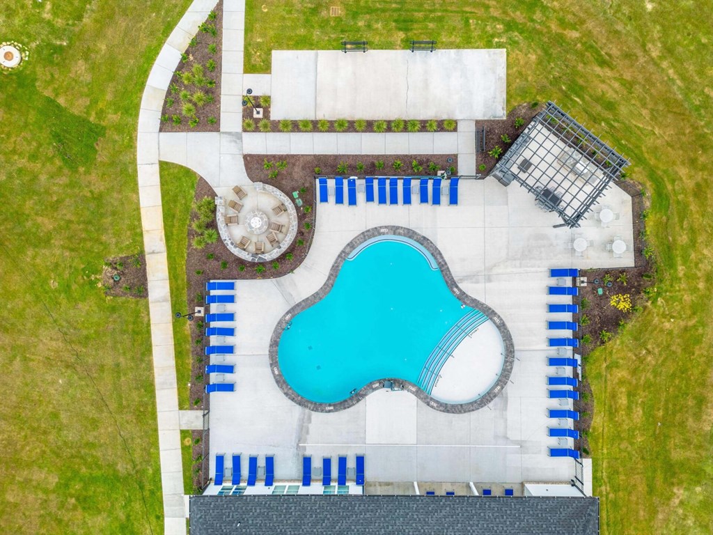 an aerial view of a swimming pool and a yard with a blue pool