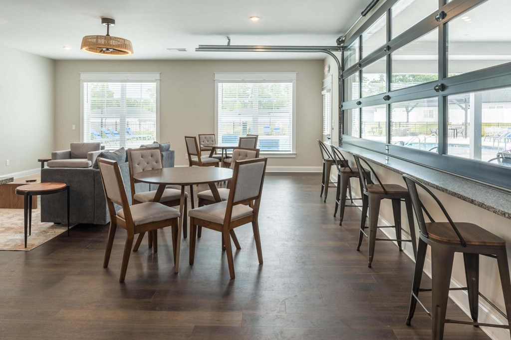 a dining room with tables and chairs in a building with large windows