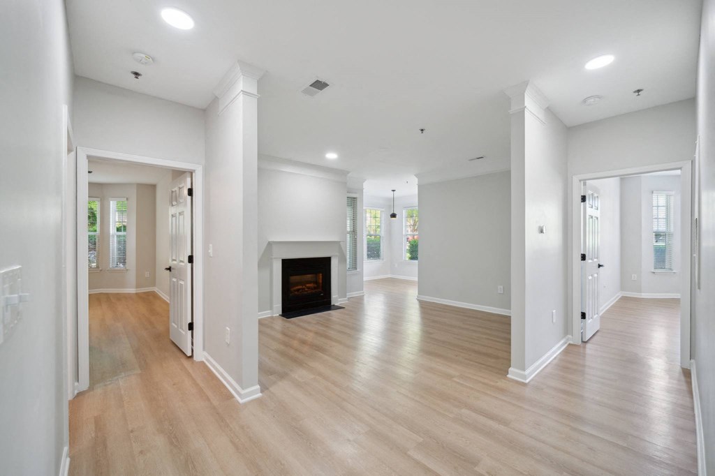 a renovated living room with a fireplace and wooden floors
