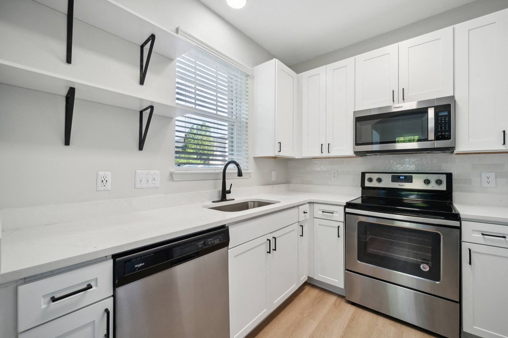 a modern kitchen with white cabinets and stainless steel appliances