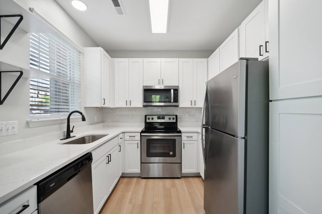 a kitchen with white cabinets and stainless steel appliances
