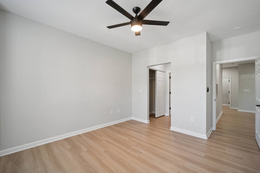 a living room with white walls and a ceiling fan