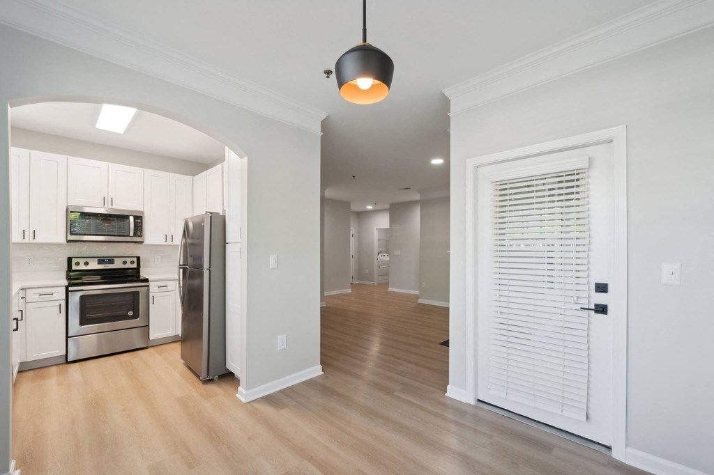 a renovated kitchen with white cabinets and stainless steel appliances