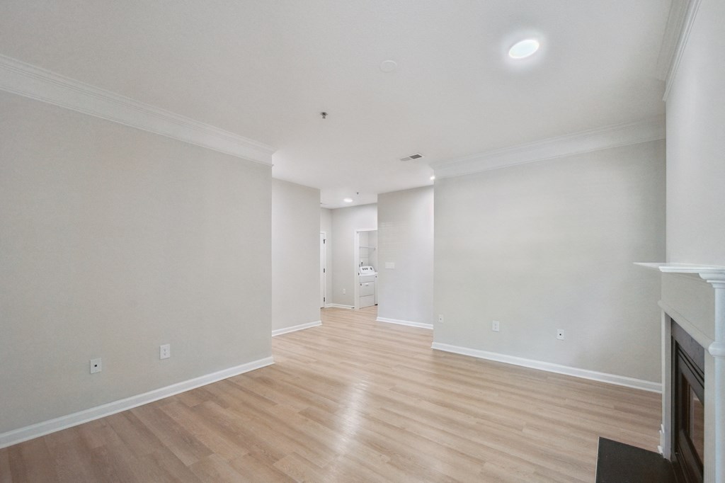 an empty living room with white walls and wood floors