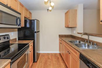 a kitchen with wooden cabinets and black appliances