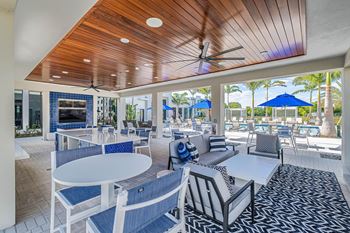 A patio with a white table and chairs with blue cushions at Altis Santa Barbara, Florida