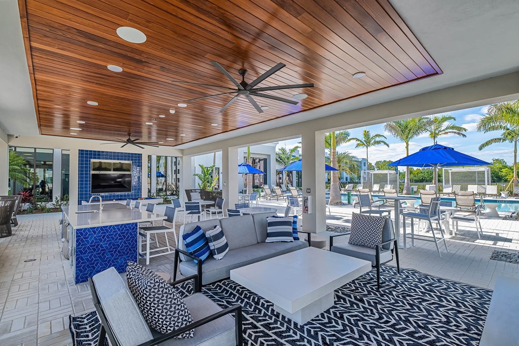 a patio with couches tables and chairs and a bar