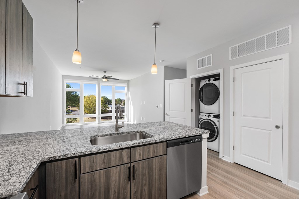 A modern kitchen with a granite countertop and stainless steel appliances.