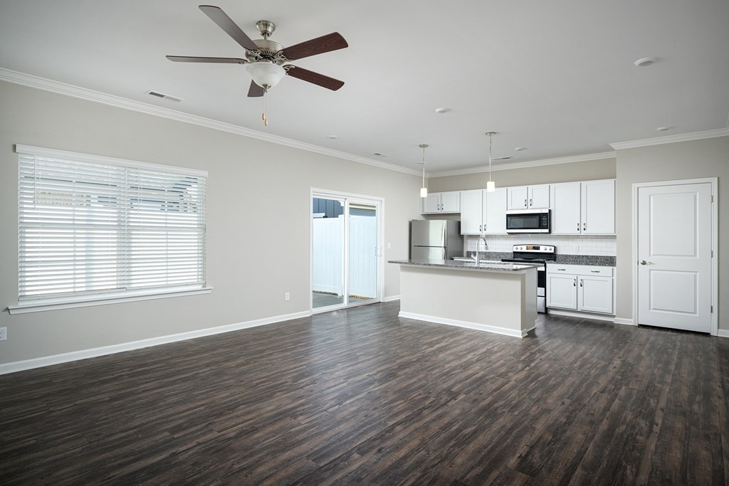 an empty kitchen and living room with a ceiling fan