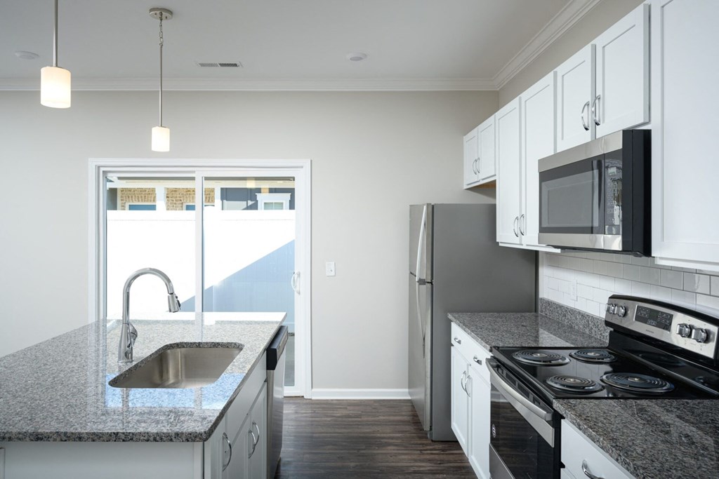 a kitchen with granite counter tops and white cabinets