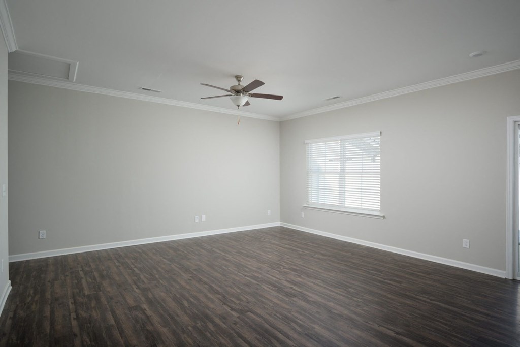 a living room with wood floors and a ceiling fan