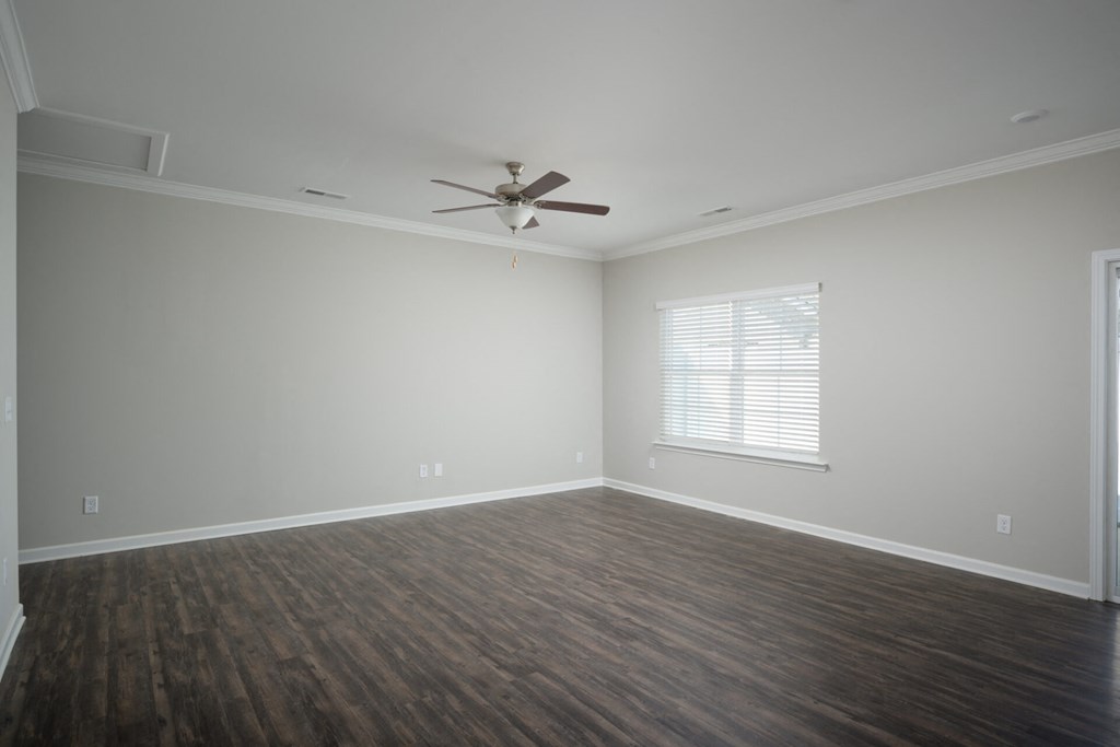 a living room with wood floors and a ceiling fan