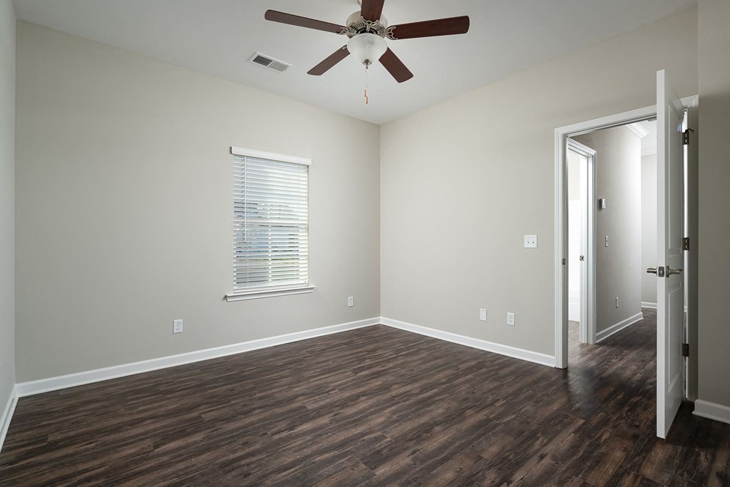 a living room with wood floors and a ceiling fan