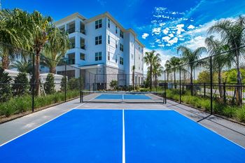 a blue tennis court with apartments in the background at Altis Grand Suncoast, Florida, 34638