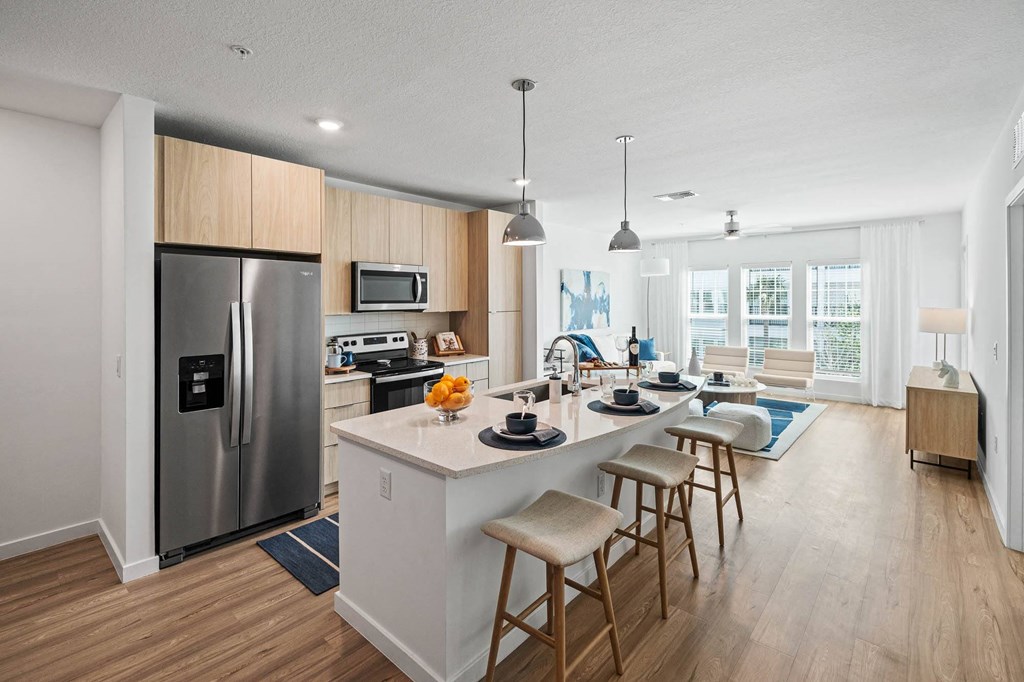 a kitchen and living room with a large island with stools