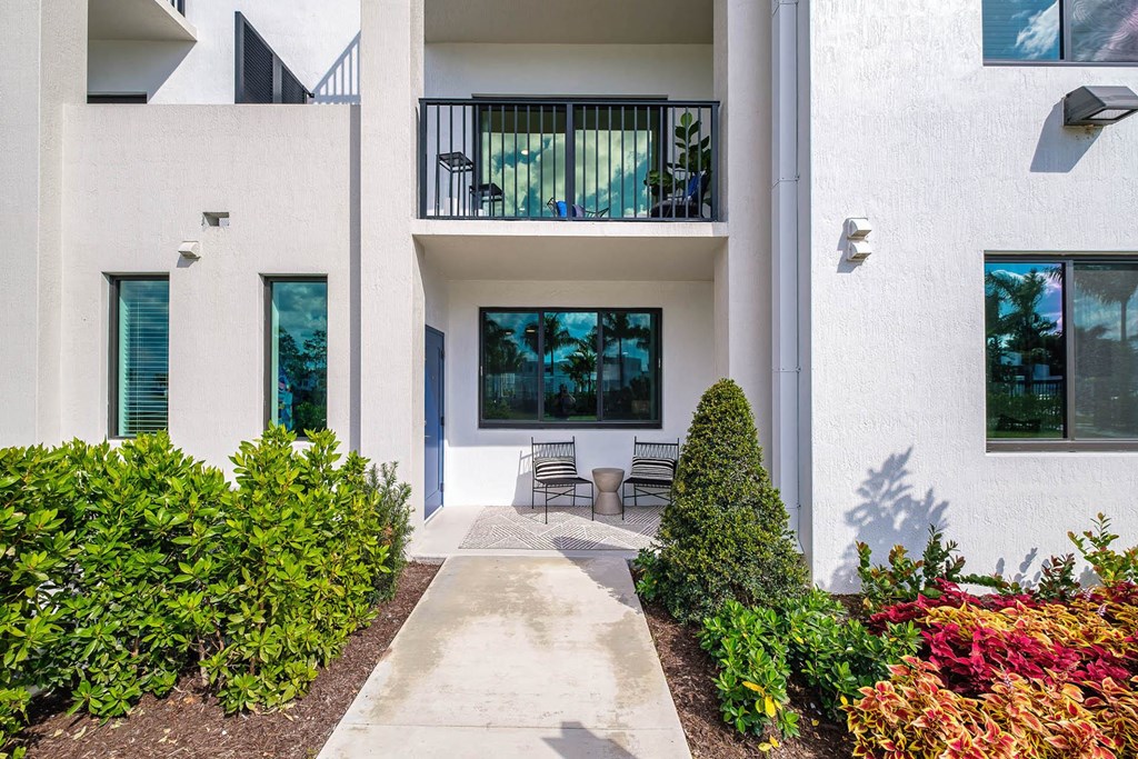 the walkway to the entrance of a building with a patio at Altis Blue Lake, Lake Worth, FL, 33467