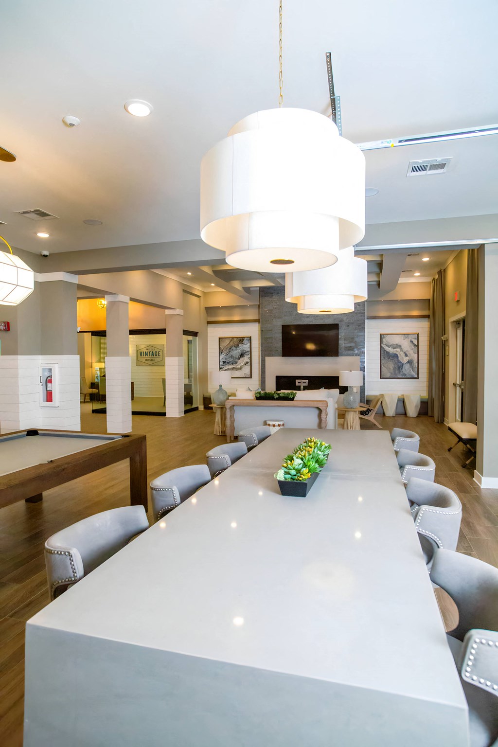 a long white table with chairs in a room