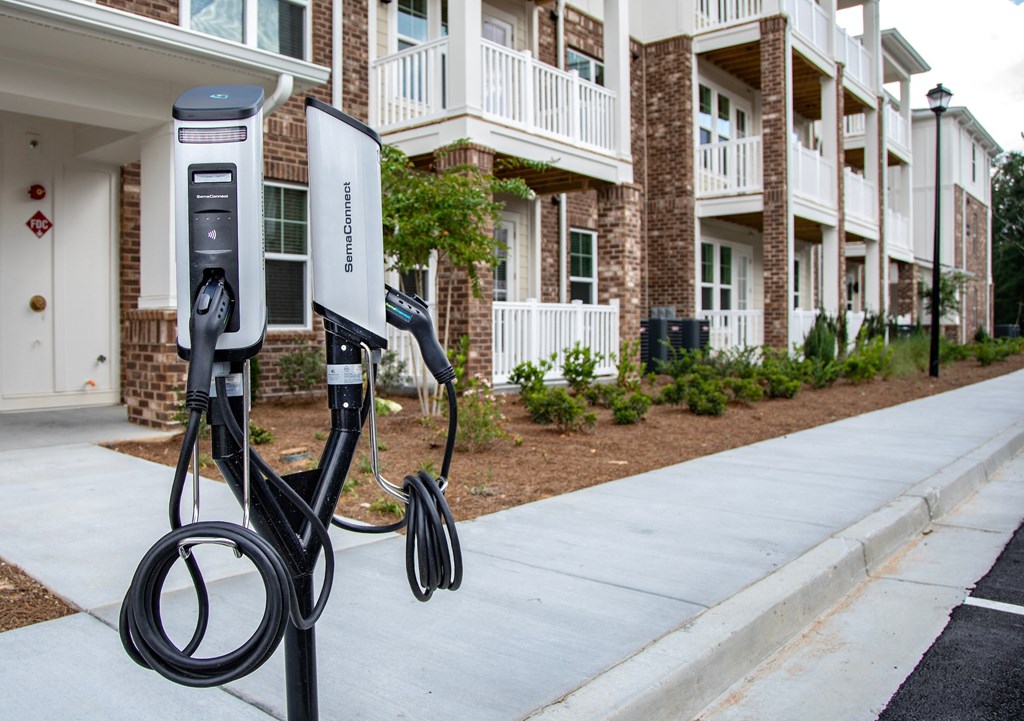 a pair of electric car chargers sit in front of an apartment building