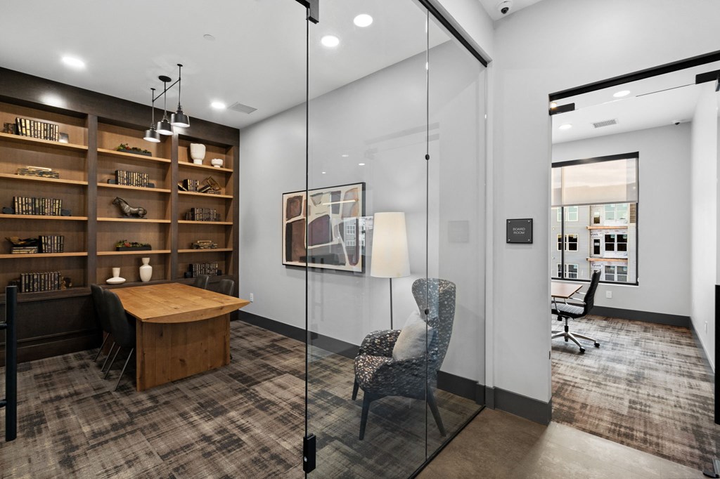 A modern office space with a wooden desk, a chair, and a bookshelf.