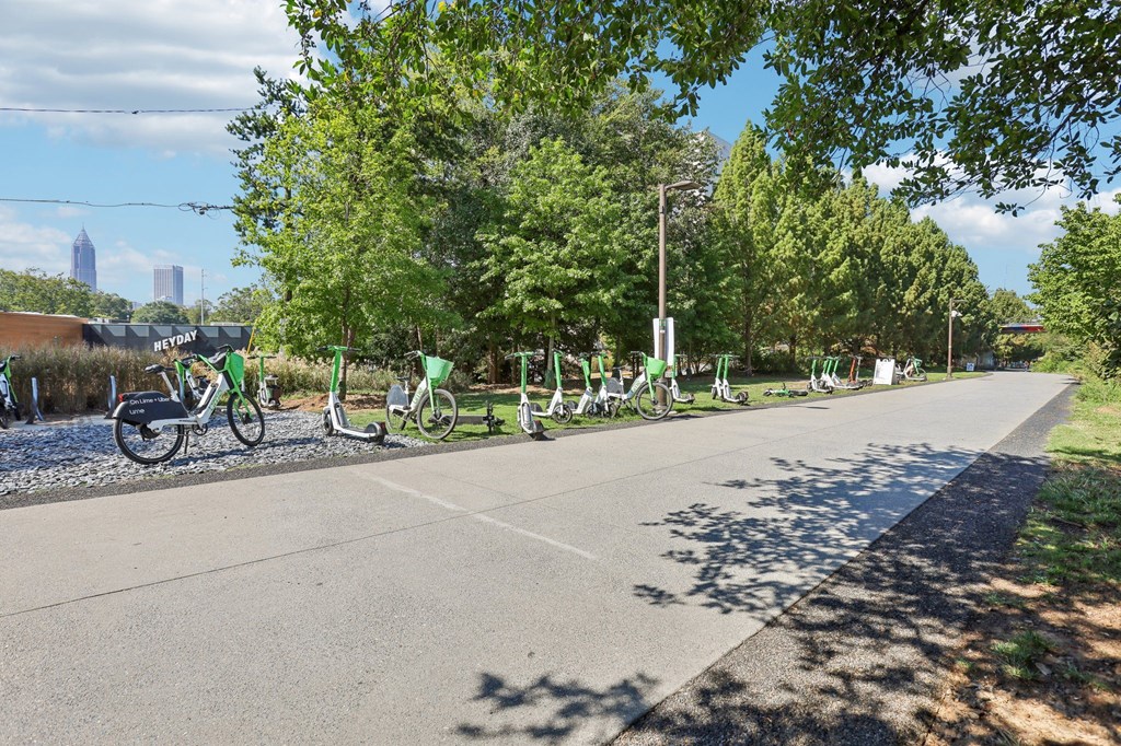 A row of bicycles are parked on the side of a road.