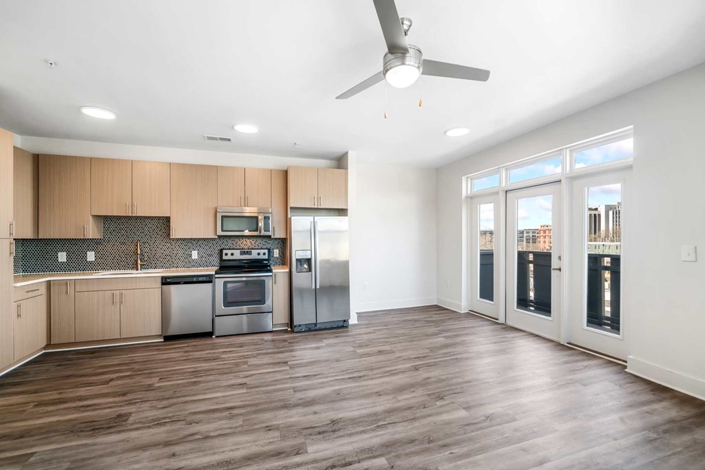 A kitchen with wooden floors and a ceiling fan.
