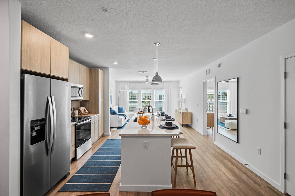 an open kitchen and dining area with a large island and stainless steel appliances