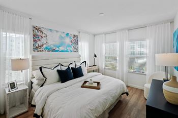 a white bedroom with a large bed and windows at Altis Twin Lakes Apartments, Kissimmee