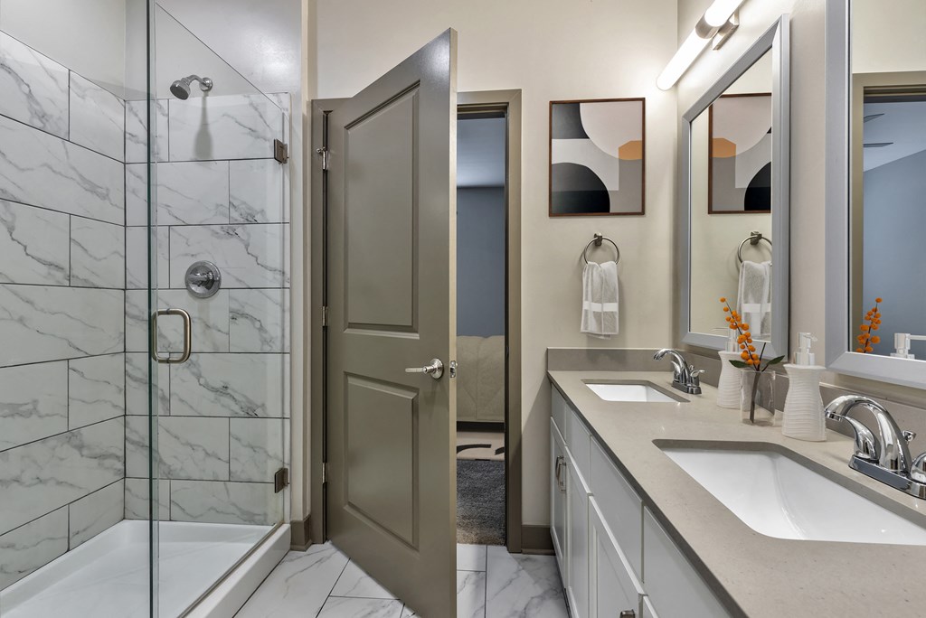 a bathroom with a shower and a sink and a mirror
