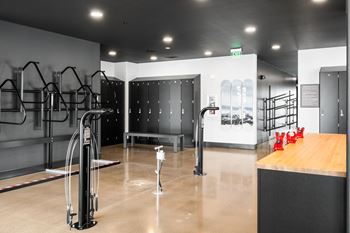 A gym with a row of treadmills and a wooden counter.