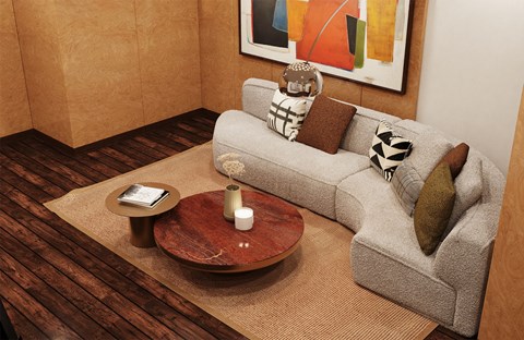 A living room with a grey couch, a coffee table, and a painting on the wall.