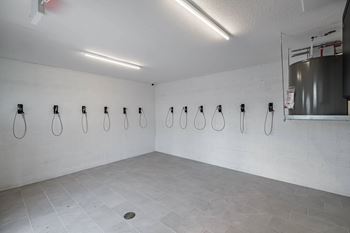 A bathroom with a row of urinals and a sink at Altis Santa Barbara, Florida