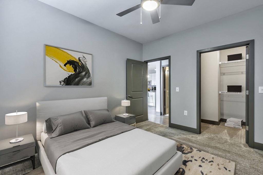 a bedroom with a white bed and a ceiling fan