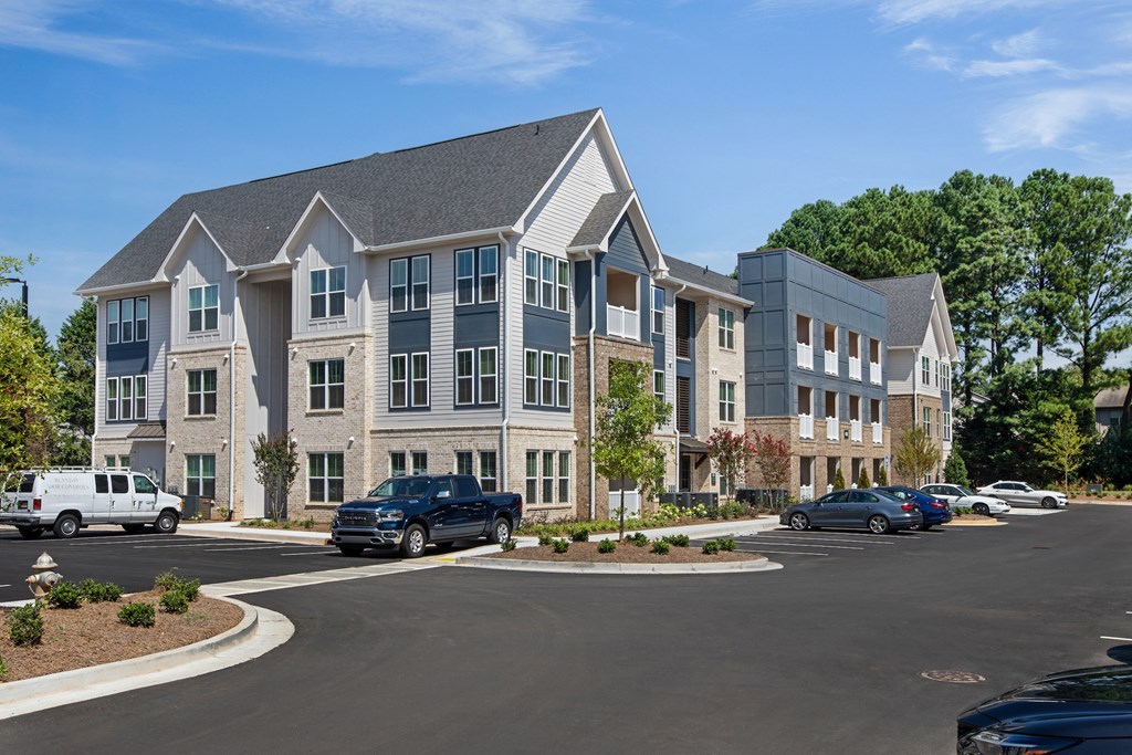 a large apartment complex with cars parked in a parking lot