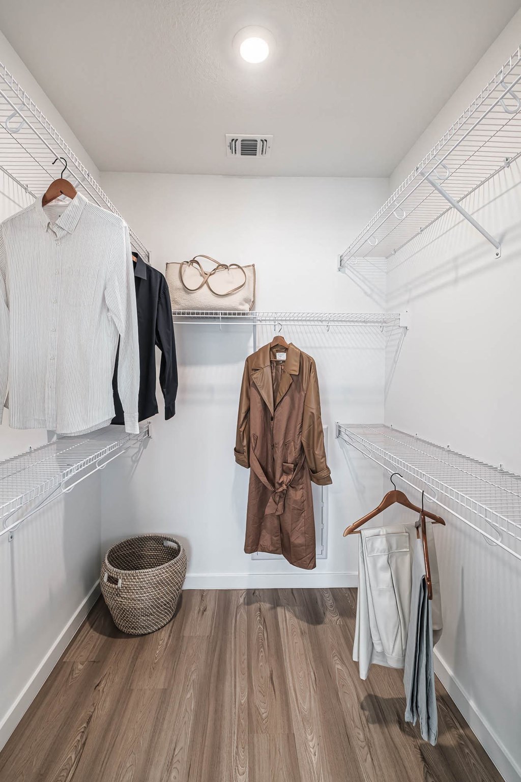 a walk in closet with coats and jackets hanging on the wall