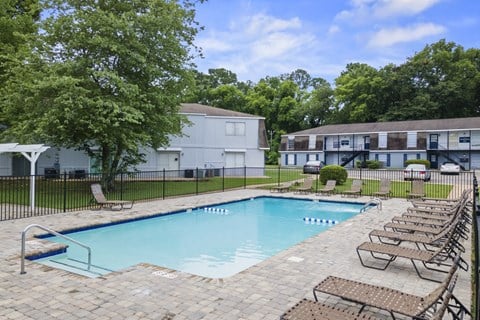 an aerial view of a swimming pool with buildings in the background