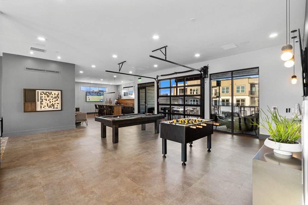 A room with a long table and chairs, a television, and a large window.