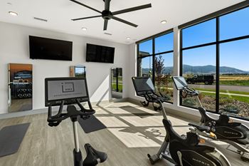 a home gym with exercise machines and a large window