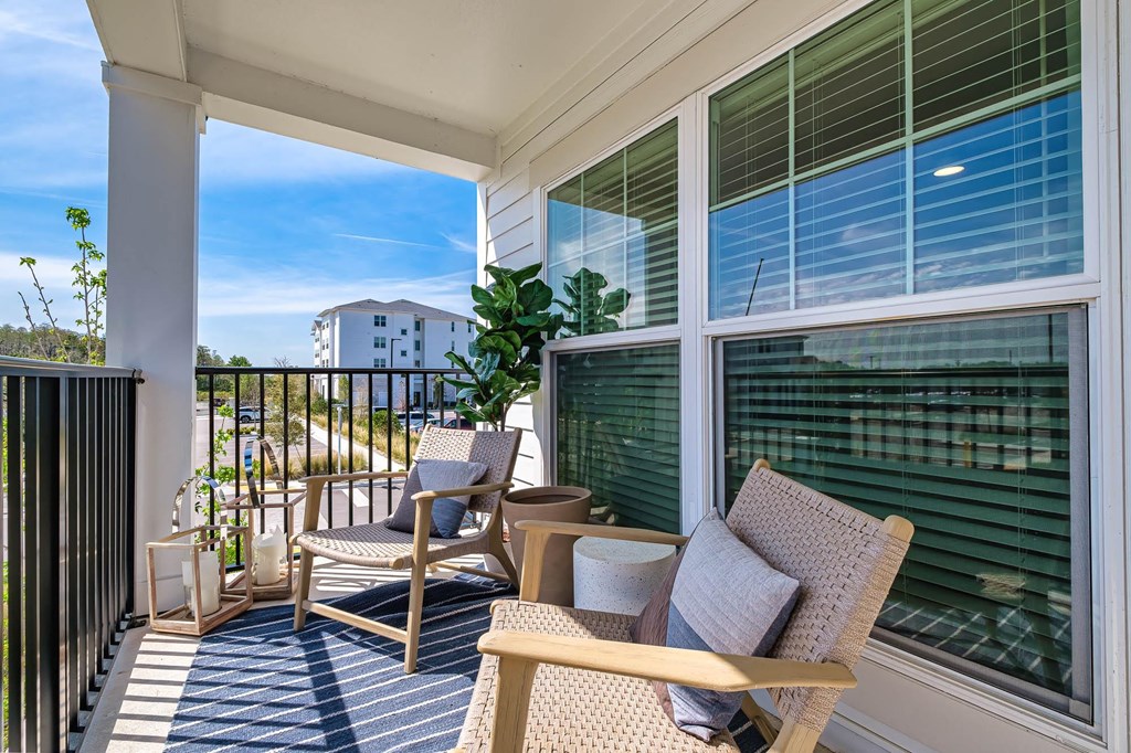 a porch with two chairs and a table and a window
