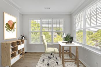 A room with a desk, chair, and a painting on the wall.