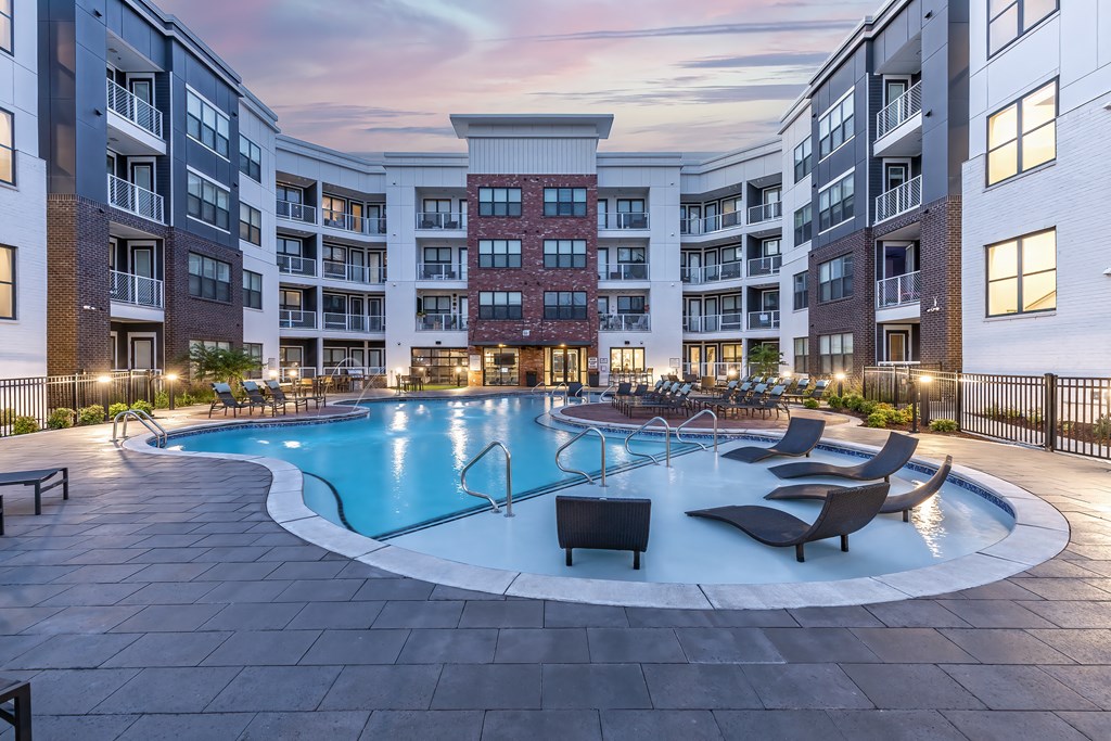 an empty swimming pool in an apartment building at dusk