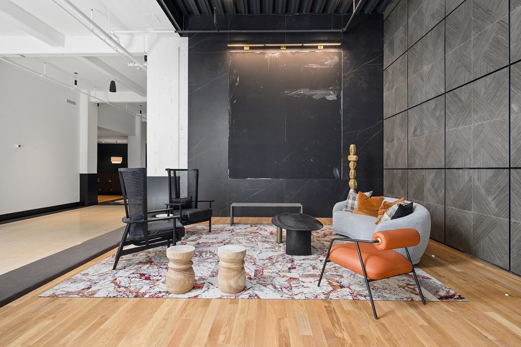 a living room with black walls and wood flooring
