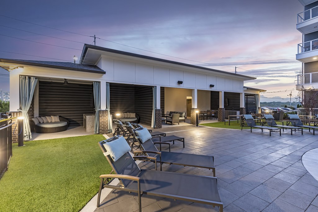 a patio with chairs and tables and a building in the background