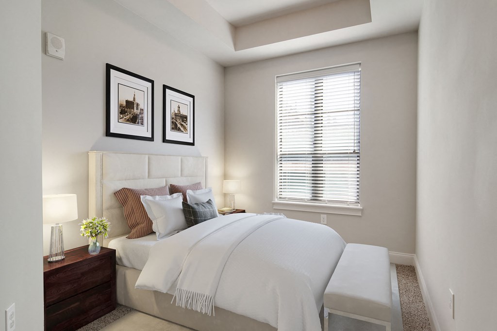 Buckhead, GA, Luxury Apartments Near Lenox Square Mall - 92 West Paces - Furnished Bedroom with White Walls, Carpet Flooring, Wooden Nightstands with Lamp, and Window with Blinds.