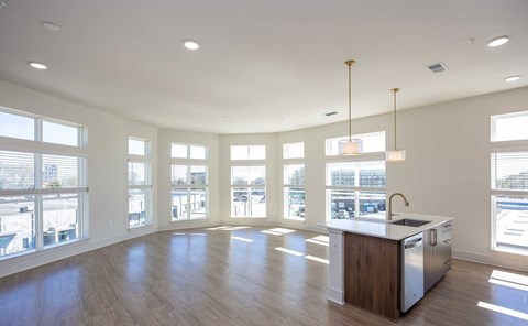 A kitchen with a large island and pendant lights.