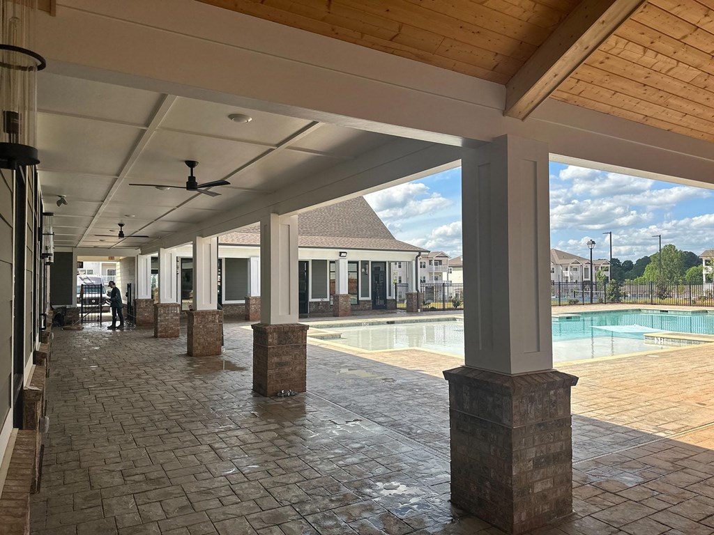 a view of a swimming pool from a covered porch with columns